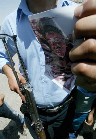 Un policía muestra una fotografía del cadáver de Jamis al Obeidi.