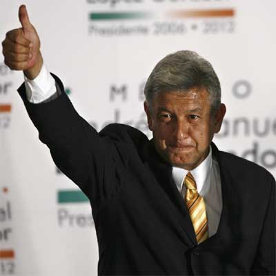 Andrés Manuel López Obrador hace el signo de la victoria en la sede de su partido.