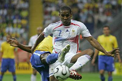 Malouda forcejea con un rival durante el partido de cuartos de final Francia-Brasil.