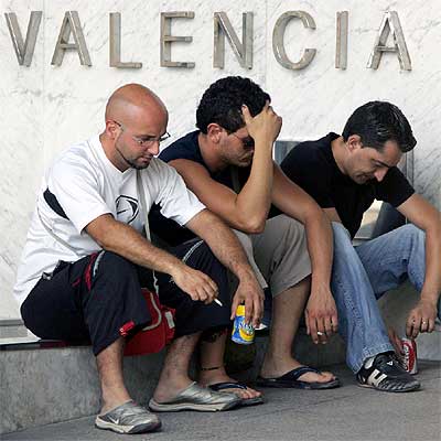 Familiares y amigos de las víctimas del accidente, sentados a la puerta del tanatorio de Valencia.