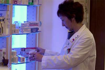 Una farmacéutica ordena medicamentos.