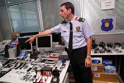 Un agente muestra el material intervenido a la banda internacional que falsificaba tarjetas.