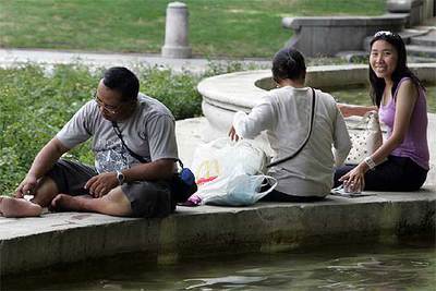 Varias personas se refrescan en una fuente de Madrid.