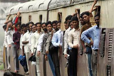 Pasajeros se asoman en un tren ayer en Bombay, donde ha vuelto a funcionar el ferrocarril tras los atentados del martes.