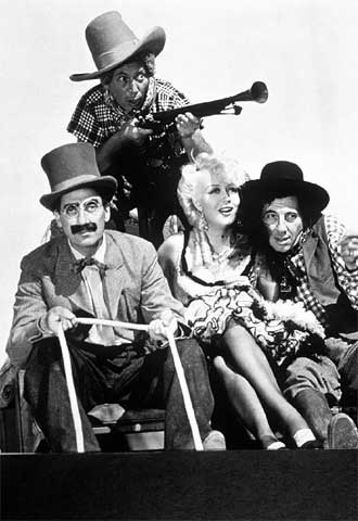 June MacCloy, entre Groucho (a la izquierda) y Chico Marx; detrás, Harpo, en un fotograma de  Los hermanos Marx en el Oeste .