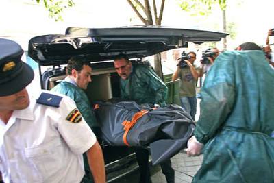 Retirada de los cadáveres hallados ayer maniatados y degollados en una vivienda incendiada en Vigo.