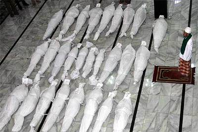 Un clérigo reza ante los cuerpos de varias víctimas del maremoto en Bulak Laut, cerca de Pangandaran.