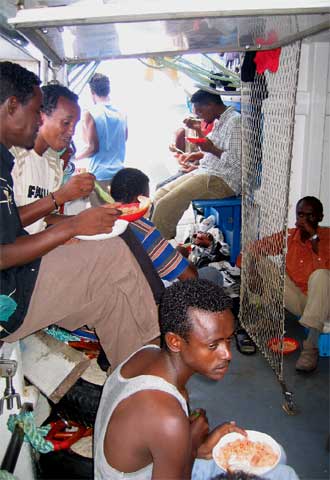Varios inmigrantes del pesquero  Francisco y Catalina,  durante la hora de la comida, antes de desembarcar.