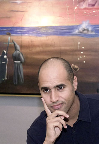 Seif el Islam el Gaddafi en 2002, ante uno de sus cuadros, titulado  El desafío , en el que opone su padre a unos monjes.