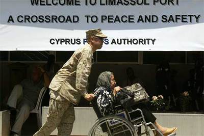 Un  marine  ayuda a una mujer norteamericana a su llegada ayer en el buque  Nashville  al puerto de Limasol, en Chipre.