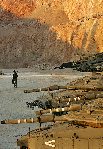 Un soldado israelí pasa por delante de una fila de tanques cerca de la frontera con Líbano.