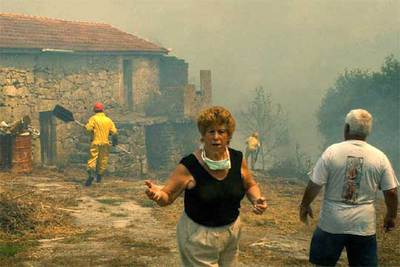 Una vecina de Outeiro (Ourense), ayer, llama a gritos a las brigadas forestales tras afectar las llamas a su casa.