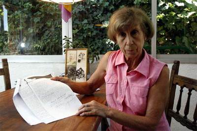 Amelia Romero, la semana pasada en el porche de su casa, muestra la condena a muerte de su padre, de 1936.