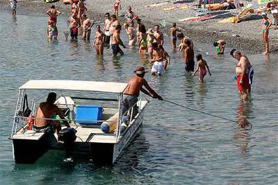 Un operario recoge medusas frente a la playa de Salobreña (Granada) el pasado lunes.