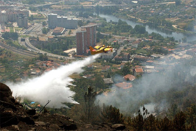 Un hidroavión vierte agua sobre varios puntos de fuego cerca del barrio orensano de O Pino.