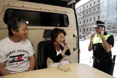 Dos turistas japoneses utilizan el nuevo servicio de atención a extranjeros de la Policía Municipal, con traducción telefónica.