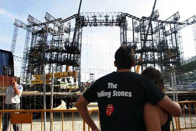 Dos seguidores del grupo miran cómo desmontan el escenario de El Ejido.