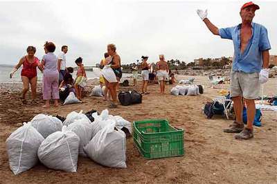 Vecinos de Alicante limpian una playa en señal de protesta