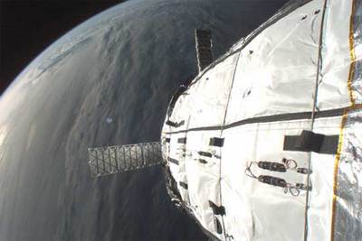 Imagen de parte del módulo hinchable  Genesis 1,  con la Tierra al fondo, tomada por una cámara adosada a su exterior.