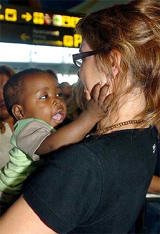 Una de las adoptantes abraza a su hija a la llegada a El Prat.