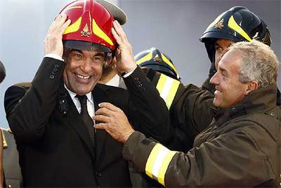 Oliver Stone recibe un casco de bombero ayer en Venecia.