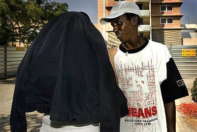 Un joven gambiano y la novia del agredido, cubierta con una chaqueta, ayer ante el hospital Taulí.