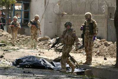 Soldados británicos junto a los cuerpos de dos víctimas mortales del atentado en Kabul.
