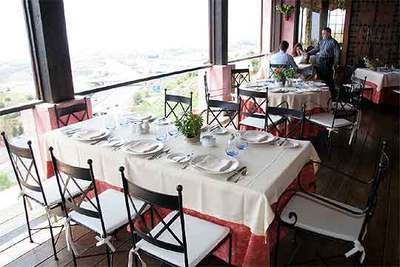 Comedor del restaurante El Higuerón, en Fuengirola. Abajo,   rossejat   de fideos con cigala.