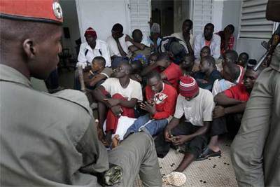 Un grupo de 27 inmigrantes espera para declarar ante el fiscal en Ziguinchor tras ser detenidos cuando viajaban en un autobús para tomar una patera.