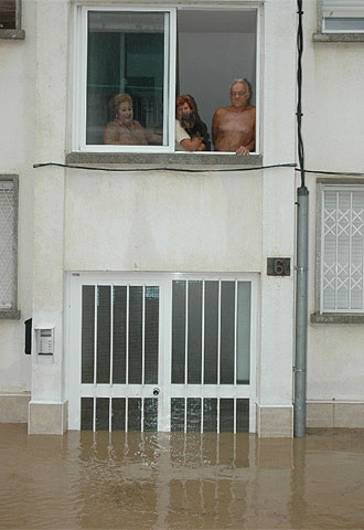 Vecinos de Salou observan los bajos de su casa inundados.