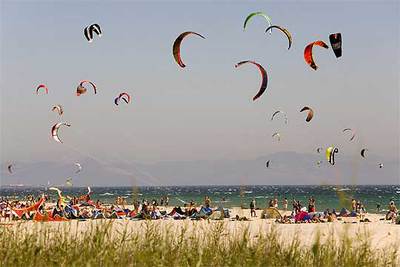 Los kitesurfistas llenan el cielo de la playa de Valdevaqueros con un espectacular baile de cometas. La práctica de esta modalidad de surf se ha multiplicado en los últimos años en la costa de Tarifa (Cádiz).