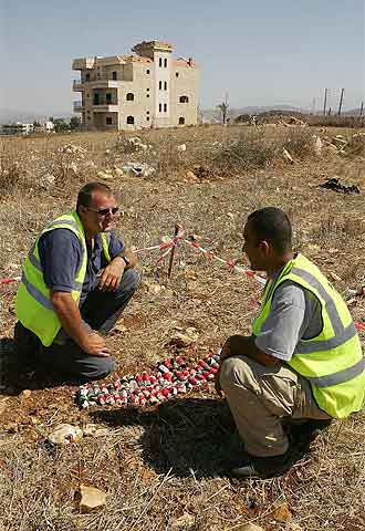 Artificieros de la empresa Bactec observan las bombas de racimo encontrada en Majdal Selem.