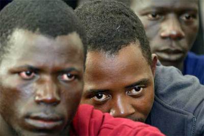 Varios de los inmigrantes que arribaron ayer en un cayuco al puerto de Los Cristianos, al sur de Tenerife.