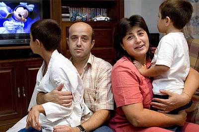 Josefa Ruiz, con su marido, Josep Martínez, en casa con sus dos hijos.