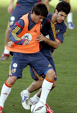 Villa, con chaleco naranja, acosado por Cesc Fabregas.