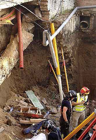 Los bomberos buscan a los obreros, atrapados el 27 de julio pasado.