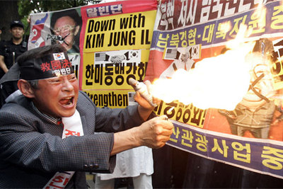 Un manifestante surcoreano quema un cartel con una imagen del dictador de Corea del Norte, Kim Jong-il, ayer en Seúl.