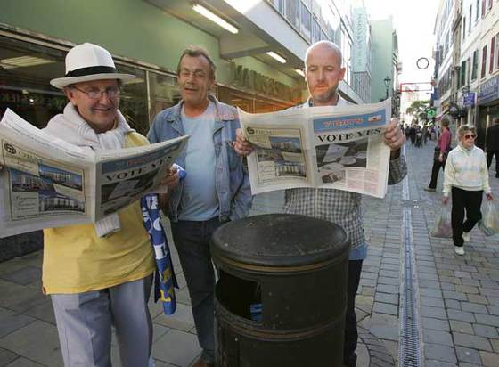 Varios ciudadanos leen en Main Street ejemplares de un diario que pide el  sí  en el referéndum.