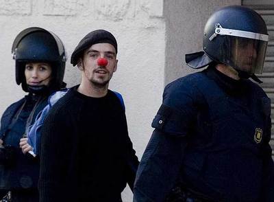 Uno de los jóvenes ocupantes de Can Ricart abandona el recinto fabril, ayer, acompañado por un  mosso d'esquadra. 