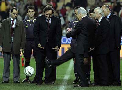 Platini, de frente en el centro, observa cómo Simon Peres realiza el saque de honor del partido.