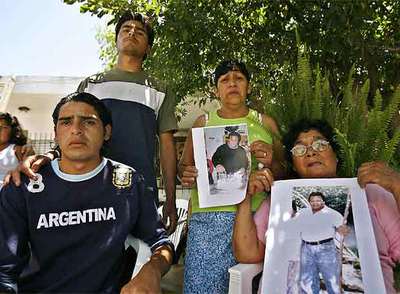 Los familiares del albañil Luis Ángel Gerez muestran sus fotografías ayer en la localidad bonaerense de Escobar.