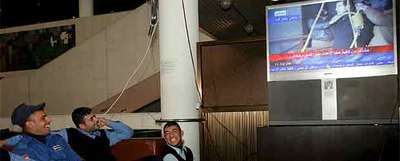 Un grupo de iraquíes sigue en Bagdad la emisión por televisión de la ejecución de Sadam Husein.