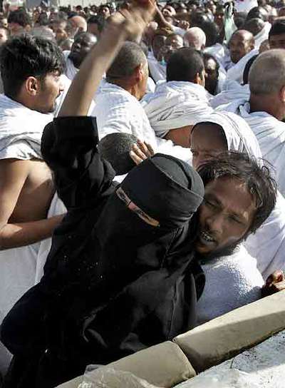Un peregrino y su esposa lanzan piedras sobre el símbolo del diablo ayer en La Meca.
