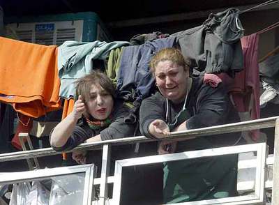 Dos mujeres iraquíes miran desde el balcón de su casa el lugar donde ayer explotó un coche bomba en Bagdad.