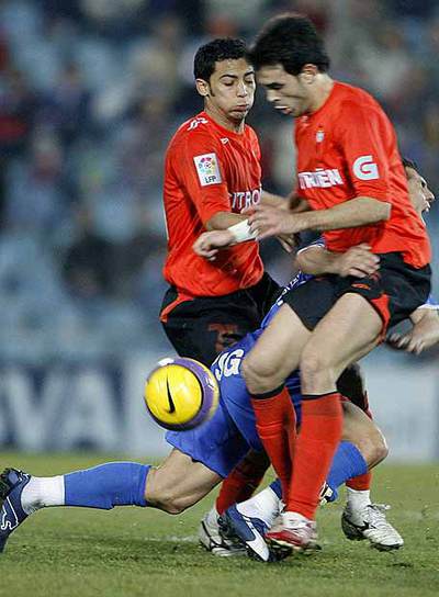 Del Moral cae sobre el césped acosado por Iriney (izquierda) y Oubiña.