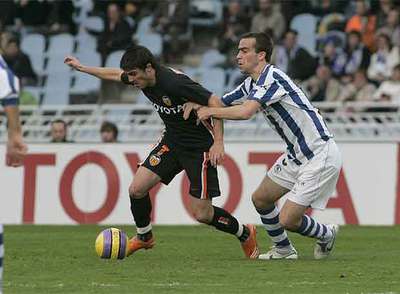 Villa, con el balón controlado, es acosado por Mikel González.