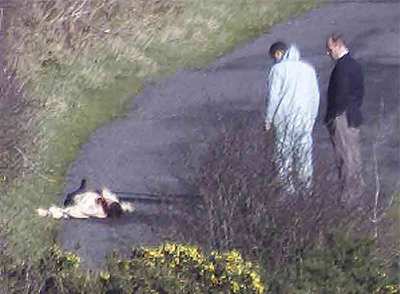 Agentes del Royal Ulster Constabulary examinan la escena de un crimen en 2000.