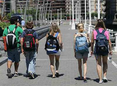 Un grupo de jóvenes turistas pasean junto a la Ría, el pasado verano, en Bilbao.