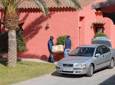 Policías de paisano llevan una caja durante el registro del domicilio del alcalde de Mogán.