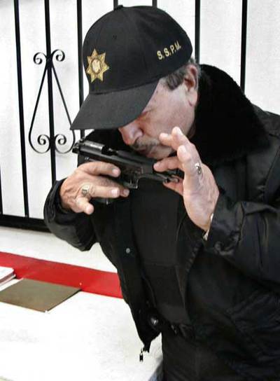 Un agente de Tijuana besa su arma reglamentaria tras recuperarla.